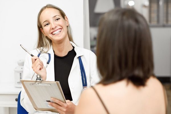 Médico estético hablando en confianza con una paciente para realizar un tratamiento estético