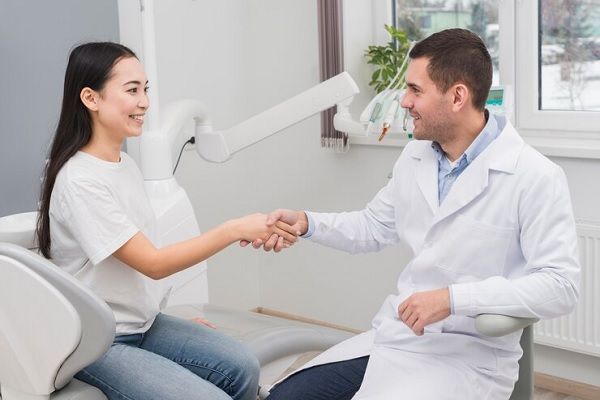 Medico y paciente dándose la mano antes de un tratamiento estético