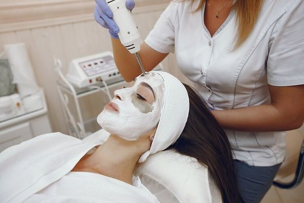 Clínica estética Madrid - Esteticista aplicando un tratamiento de rejuvenecimiento facial a una mujer en la mejor clínica estética Madrid