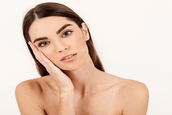 Mujer joven con rostro perfecto gracias a los tratamientos de rejuvenecimiento facial realizados en la mejor clínica estética Madrid