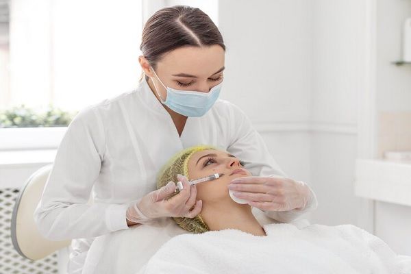 Mejor clínica ácido hialurónico Madrid - Especialista aplicando un tratamiento de ácido hialurónico para rejuvenecer el rostro de una mujer
