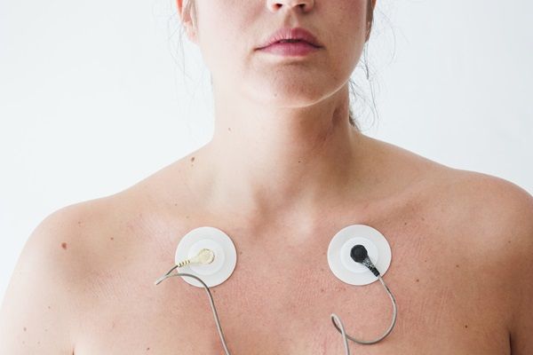 mujer usando electroestimuladores en su pecho 