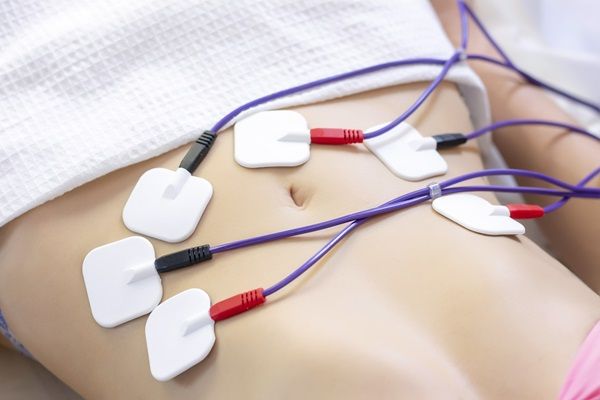 tratamiento con electroestimulador en abdomen de mujer