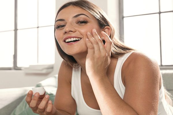chica joven aplicando cuidados de la piel