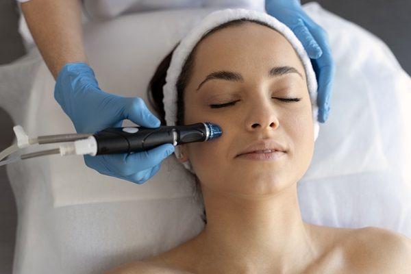 especialista aplica dermapen a mujer en el rostro