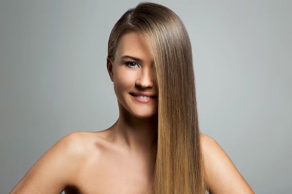 mujer joven de pelo hermoso luego de aplicar bótox capilar