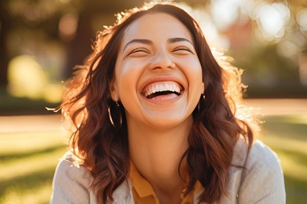 Mujer joven con sonrisa gingival sonrie al aire libra