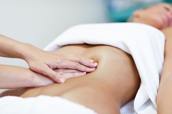 Masajes - Masajista aplicando diferentes tipos de masajes para aplanar el abdomen de una mujer