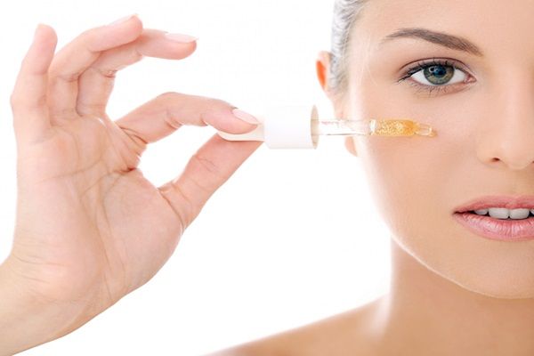 Niacinamida - Mujer joven aplicándose un serum niacinamida en la piel del rostro