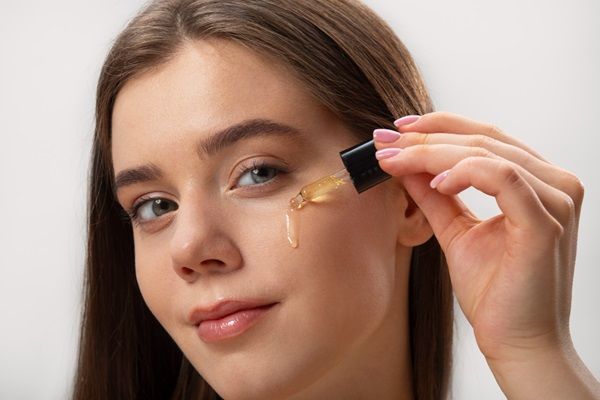 Mujer aplicándose un serum contra el envejecimiento para la piel del rostro