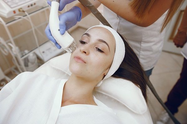 Aparatología estética - Especialista utilizando aparatos de estética para rejuvenecer la piel del rostro de una mujer