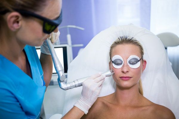 Aparatología estética - Médico estético usando un aparato de radiofrecuencia para rejuvenecer el rostro de una mujer entre los beneficios aparatología estética