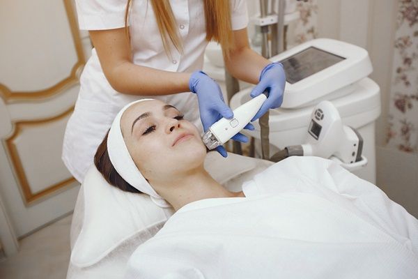 Mujer realizándose un tratamiento estético facial en la mejor clínica estética Madrid