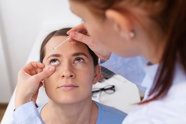 Médico realizando un examen ocular a una mujer joven para detectar problemas de la vista