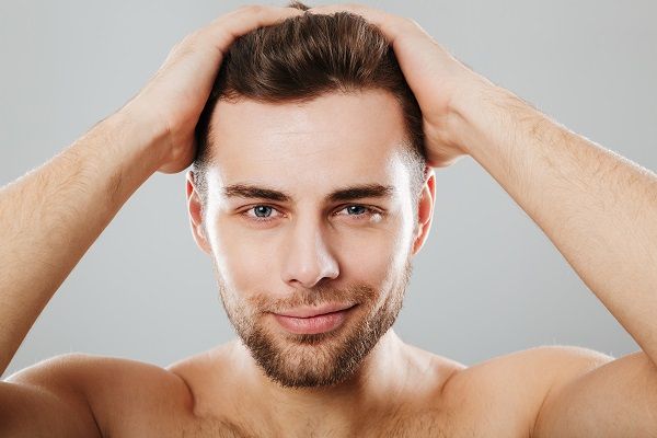 Bótox capilar - Hombre joven tocando su cabello sano luego del botox capilar