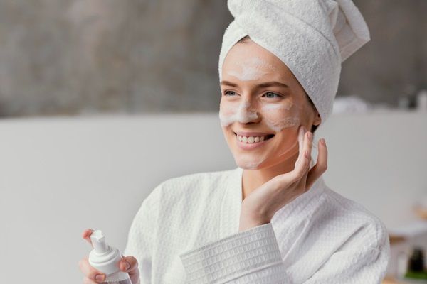 Cómo hidratar la piel - Mujer joven aplicándose una crema hidratante en la piel del rostro