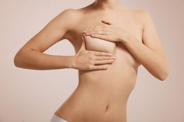 Mastopexia sin implantes - Mujer usando sus manos para observar cómo quedaría un levantamiento de senos sin implantes