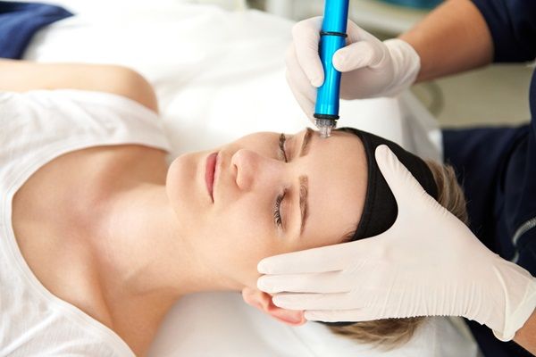 Esteticista realizando un tratamiento con Dermapen para estimular la producción de colágeno y elastina en la piel del rostro