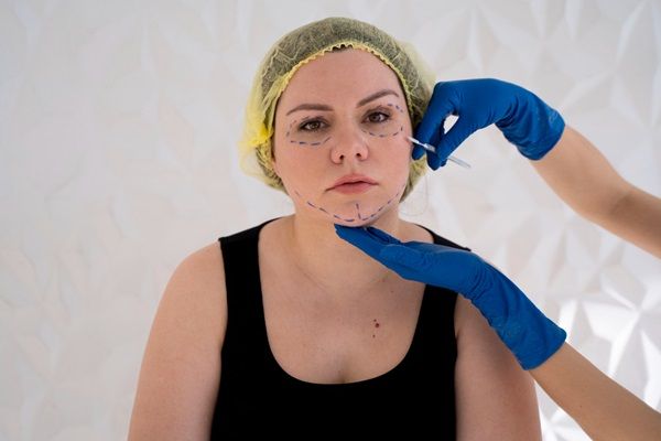 Tratamientos estéticos sin cirugía – Médico realizando un tratamiento estético para eliminar las arrugas faciales de una paciente mujer