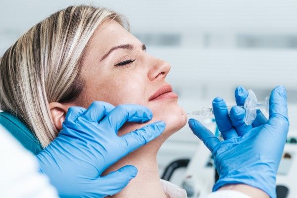 rellenos faciales - mujer en la consulta del especialista sometiéndose a un relleno facial