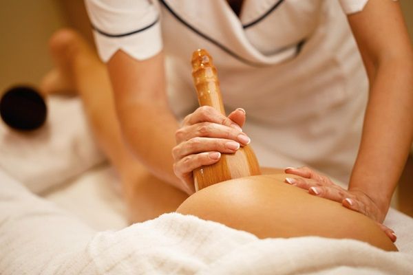 Maderoterapia - Fisioterapeuta utilizando una copa sueca de madera para eliminar la celulitis con un tratamiento de maderoterapia antes y después de su aplicación