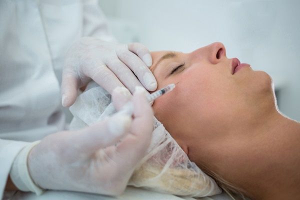 Tratamiento hidratación profunda - Médico estético aplicando una inyección de ácido hialurónico para hidratar la piel del rostro de una mujer en la mejor clinica acido hialuronico Madrid