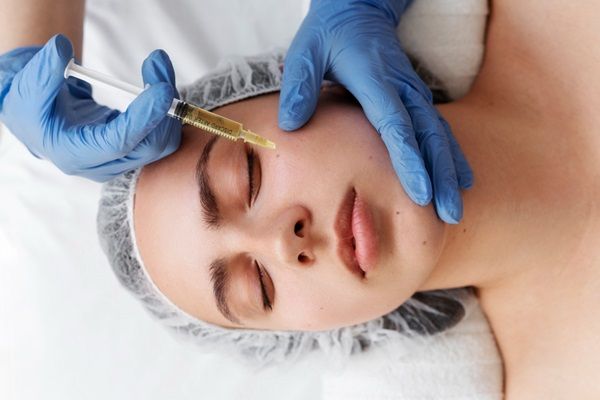 Tratamiento hidratación profunda - Médico especialista aplicando un tratamiento con acido hialuronico Madrid para una hidratación profunda del rostro de una mujer