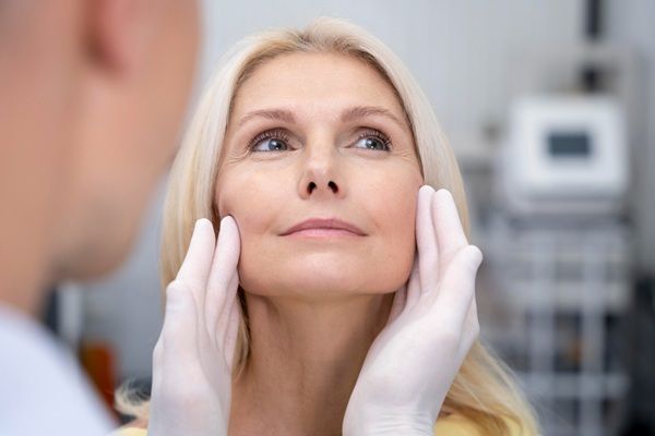 Facetem - Médico estético evaluando el rostro de una mujer para realizar un tratamiento de rejuvenecimiento en la mejor clínica estética Madrid