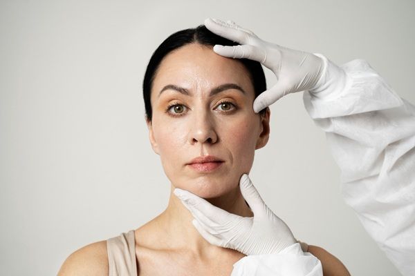 Facetem - Esteticista tocando el rostro de una mujer para recomendar el mejor tratamiento de rejuvenecimiento facial