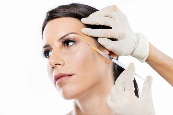 Efectos secundarios del bótox - Médico estético aplicando un tratamiento de toxina botulínica a una mujer en la clínica de mejor precio bótox Madrid