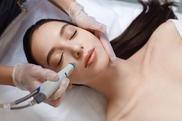 Exion - Médico facial aplicando un tratamiento con inteligencia artificial para rejuvenecer el rostro de una mujer