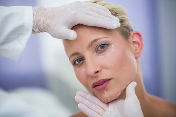 Relleno ácido hialurónico - Médico estético evaluando el rostro de una mujer para determinar el tratamiento de rejuvenecimiento facial con ácido hialurónico en la mejor clínica ácido hialurónico Madrid