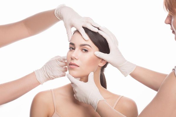 Tendencias en tratamientos estéticos - Esteticistas evaluando el rostro de una mujer luego de realizar tratamientos estéticos en la mejor clínica estética Barcelona
