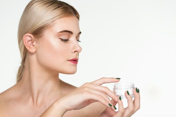 Ácido hialurónico Barcelona - Mujer aplicándose cremas con ácido hialurónico para estimular la producción de colágeno y elastina