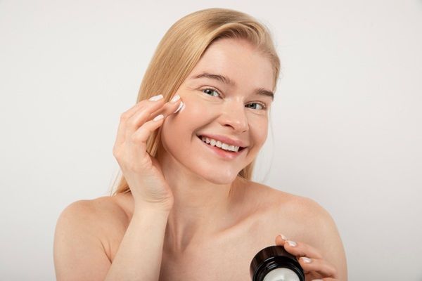Mujer aplicándose cremas hidratantes en el rostro para hidratar la piel