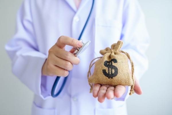 Médico sosteniendo un saco con dinero referente a los precios tratamientos estéticos Barcelona