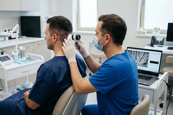 Tricólogo evaluando la densidad del área occipital de un paciente en la mejor clínica trasplante capilar
